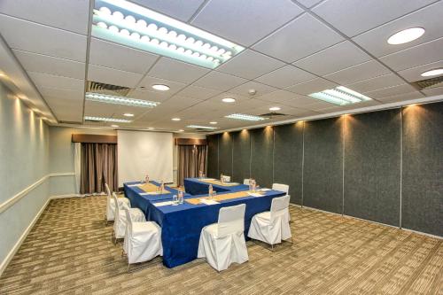 a conference room with a blue table and white chairs at Holiday Inn Leon-Convention Center by IHG in León