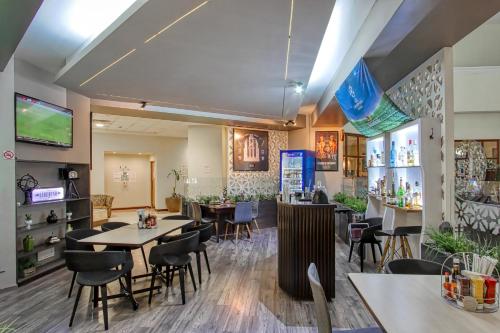 a restaurant with tables and chairs and a bar at Holiday Inn Leon-Convention Center, an IHG Hotel in Le&oacute;n