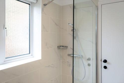 a shower with a glass door in a bathroom at South Downs Garden Cottage in Old Town