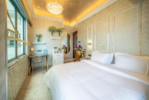 a bedroom with a large white bed and a desk at Ritz Residence, Imago Mall Loft B in Kota Kinabalu