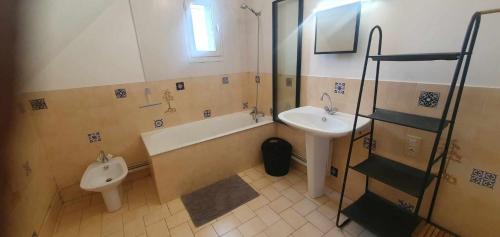 a bathroom with a sink and a tub and a toilet at Le bien être aux forges in Céaux