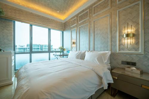a bedroom with a white bed and a large window at Ritz Residence, Imago Mall Loft B in Kota Kinabalu
