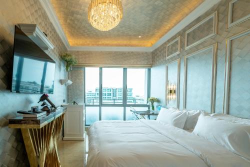 a bedroom with a white bed and a large window at Ritz Residence @ Imago Loft B 7th Floor in Kota Kinabalu