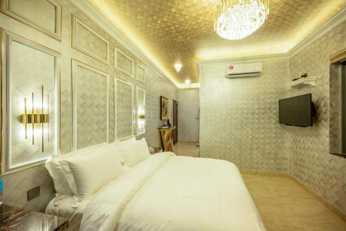 a bedroom with a large white bed and a tv at Ritz Residence, Imago Mall Loft B in Kota Kinabalu
