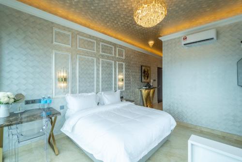 a bedroom with a large white bed and a table at Ritz Residence, Imago Mall Loft B in Kota Kinabalu
