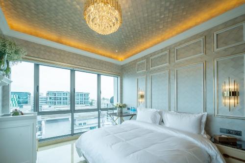 a bedroom with a large white bed and a large window at Ritz Residence, Imago Mall Loft B in Kota Kinabalu