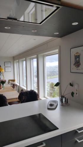 Modern family home in Voss في فوسفافنغان: غرفة مع مطبخ مع طاولة ونوافذ