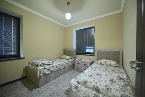 a bedroom with two beds and two windows at ArtStar in Sevan