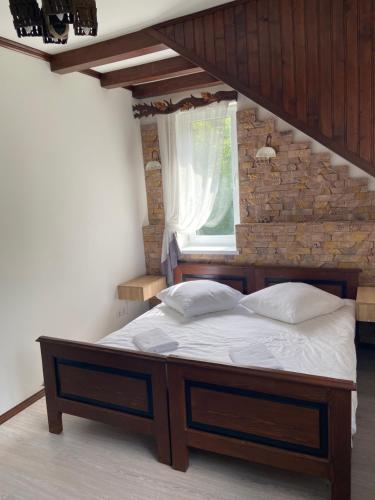 a bed in a bedroom with a brick wall at Hotel Tys in Dilove