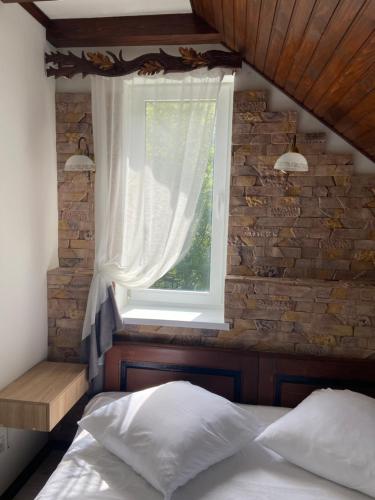 a bedroom with a bed and a window at Hotel Tys in Dilove