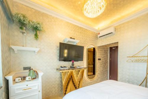 a bedroom with a bed and a tv on the wall at Ritz Residence, Imago Mall Loft B in Kota Kinabalu