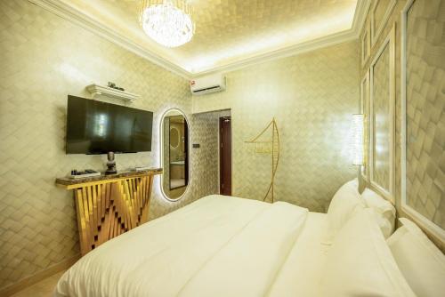 a bedroom with a large white bed and a television at Ritz Residence, Imago Mall Loft B in Kota Kinabalu
