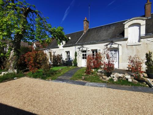 Uma casa branca com uma entrada à frente. em La Jacquière em Chaumont-sur-Loire