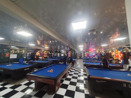 a row of pool tables in a room with checkered floors at Hero Hostel & Billiards in Chau Doc