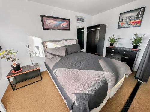 sypialnia z łóżkiem i stołem z roślinami w obiekcie Whitaker Wish- Spacious, city based apartment with carpark w Auckland