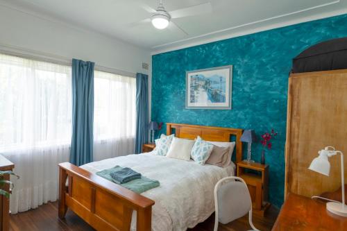 a bedroom with a bed and a blue wall at Kurranulla Sapphire - U3 in Cronulla