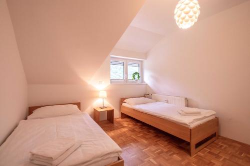 2 camas en una habitación pequeña con ventana en River Valley Vista Apartment, en Bohinjska Bela