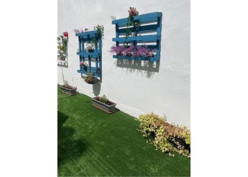 a garden with three blue flower boxes on a wall at Hotel Acebo Plaza Mayor in Jaca