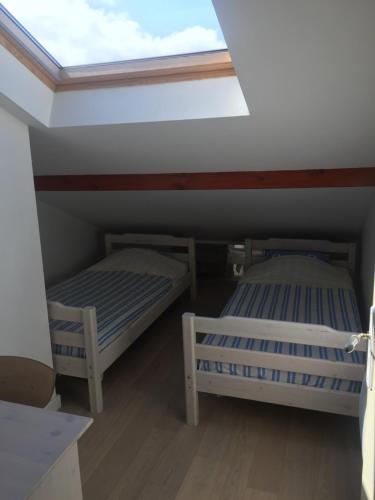twee bedden in een kamer met een dakraam bij Appartement côte des basques in Biarritz