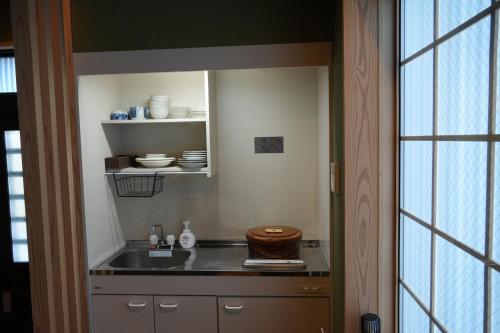 a small kitchen with a sink and a mirror at Kyoto-cocoro house in Kyoto