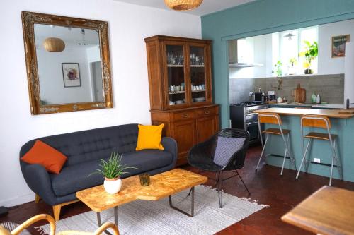 a living room with a couch and a kitchen at La Bycoque, maison au calme près de Fontainebleau in Thomery