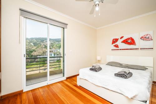 a bedroom with a bed and a large window at Bela Vista Valley in Calheta
