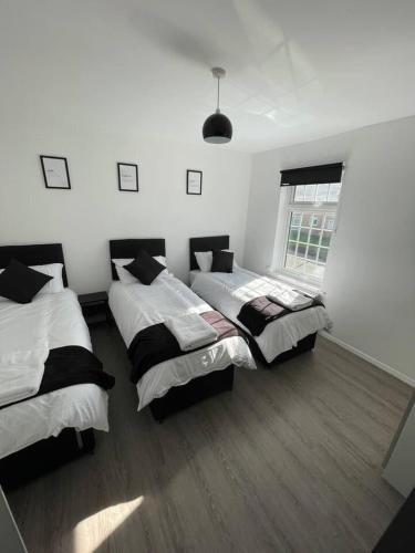 a bedroom with two beds and a window at Luxury Spacious 2-Bed House in Brentwood Essex in Brentwood