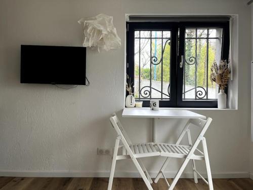 a white table and chair in a room with a window at Studio Strasbourg avec jardin in Strasbourg