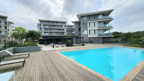 an apartment building with a swimming pool in front of a building at Luxury Beach Getaway@Coral Point in Sibaya