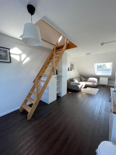 ein Wohnzimmer mit einer Treppe und einer Couch in der Unterkunft Gemütliche Dachgeschosswohnung in Mönchengladbach in Mönchengladbach