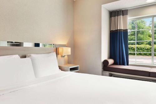 a hotel room with a bed and a window at Microtel Inn & Suites by Wyndham Florence/Cincinnati Airpo in Florence