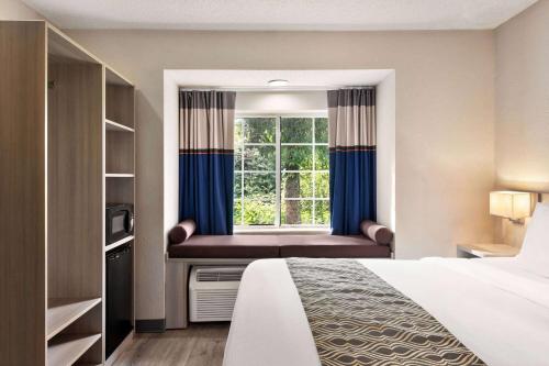 a hotel room with a bed and a window at Microtel Inn & Suites by Wyndham Florence/Cincinnati Airpo in Florence