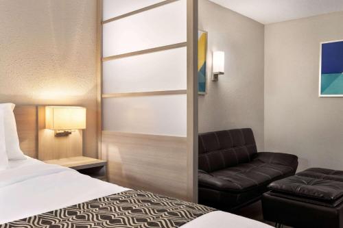 a hotel room with a bed and a couch at Microtel Inn & Suites by Wyndham Florence/Cincinnati Airpo in Florence