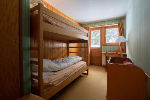 a bedroom with two bunk beds and a window at Chalet Robaumont - Grand chalet familial proche du centre et des pistes in Courchevel