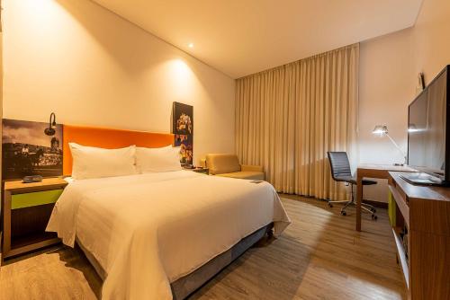 a hotel room with a bed and a desk at Hampton by Hilton Cartagena in Cartagena de Indias