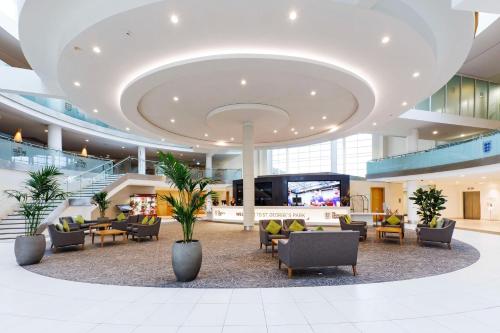 a lobby with couches and chairs in a building at Hilton at St George's Park in Burton upon Trent