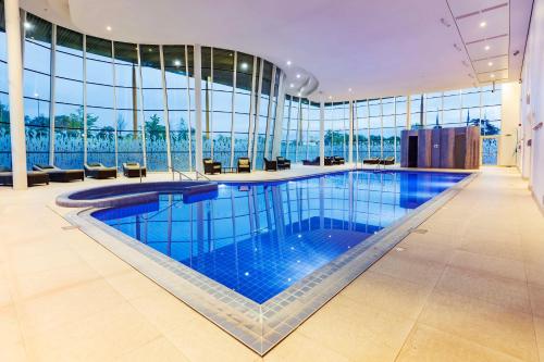 a large swimming pool in a building with windows at Hilton at St George's Park in Burton upon Trent