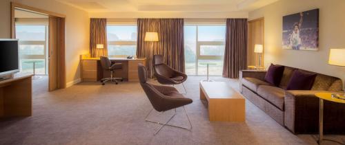 a living room with a couch and chairs at Hilton at St George's Park in Burton upon Trent