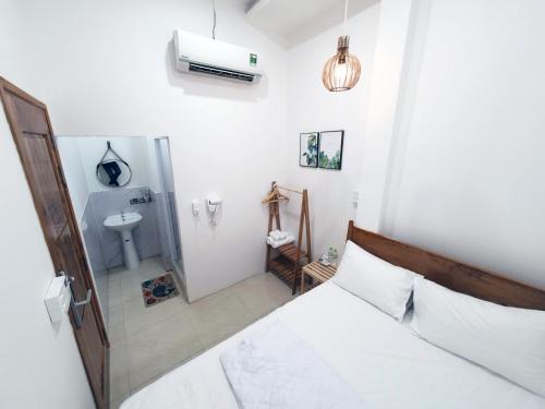 a bedroom with a bed and a bathroom with a sink at Hero Hostel & Billiards in Chau Doc
