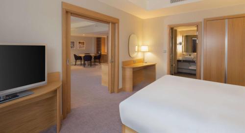 a hotel room with a bed and a television at Hilton at St George's Park in Burton upon Trent