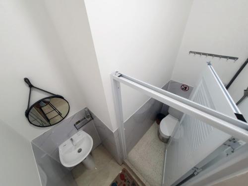 a white bathroom with a urinal and a toilet at Hero Hostel & Billiards in Chau Doc