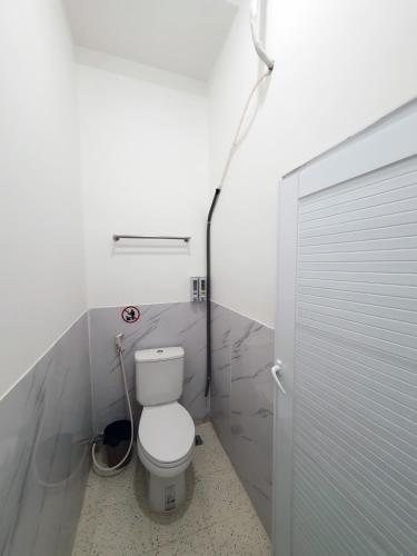 a bathroom with a toilet and a shower door at Hero Hostel & Billiards in Chau Doc