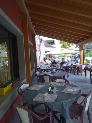 a restaurant with tables and chairs and people sitting at tables at Albergo Alla Posta in Anduins