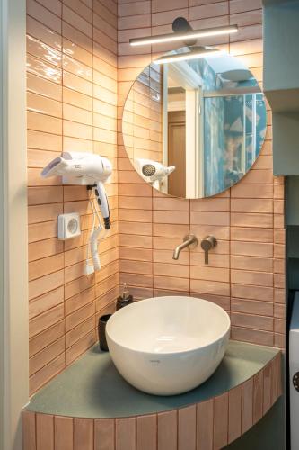 a bathroom with a white sink and a mirror at Pink Panther Maisonette Suite in Argostoli