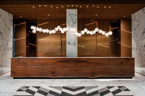 uno spogliatoio con panca in legno e lampadario pendente di The Alloy, a DoubleTree by Hilton - Valley Forge a King of Prussia