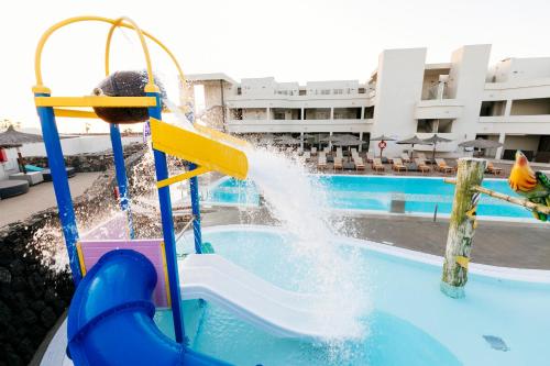 a child playing on a water slide in a pool at HD Beach Resort in Costa Teguise