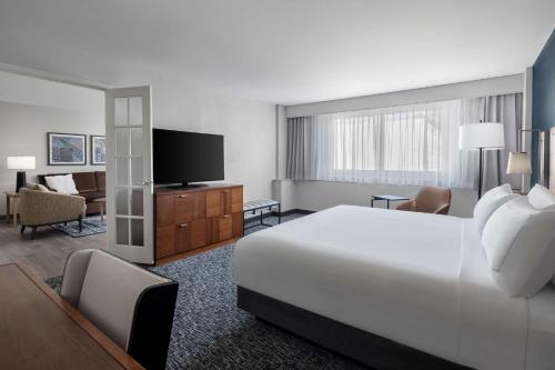 a hotel room with a bed and a flat screen tv at The Alloy, a DoubleTree by Hilton - Valley Forge in King of Prussia