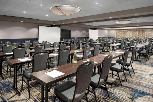 a conference room with tables and chairs and a projection screen at The Alloy, a DoubleTree by Hilton - Valley Forge in King of Prussia