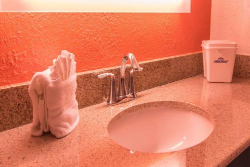 een badkamerbar met een wastafel en een handdoek bij Howard Johnson by Wyndham Portsmouth in Portsmouth