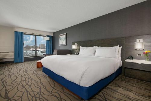 a large white bed in a hotel room with a window at DoubleTree by Hilton Racine Harbourwalk in Racine